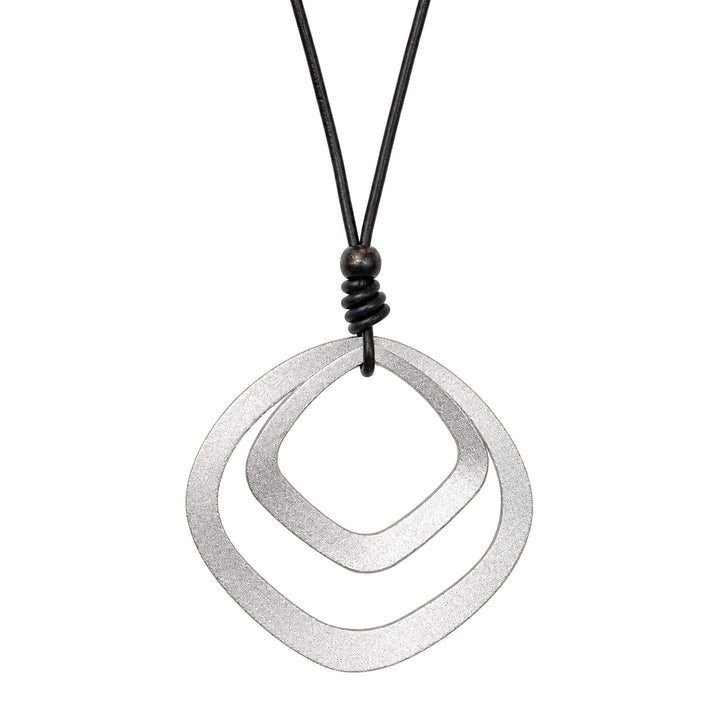 Ett långt svart halsband med två fyrkantiga hängsmycken i silver
