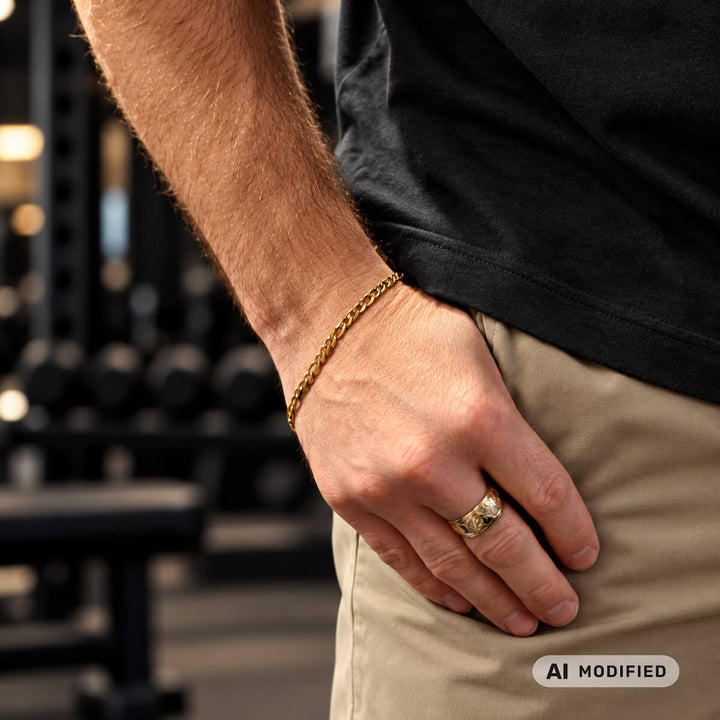 A gold-plated steel bracelet with a Figaro chain on a man's wrist