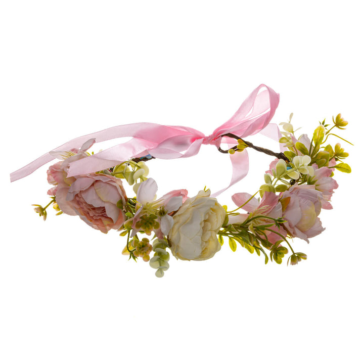 En ljusrosa blomsterkrans med en vit ros