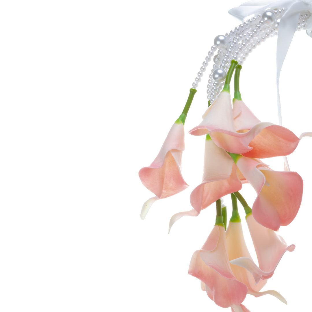 A calla lily bridal bouquet with a peach-colored artificial flower